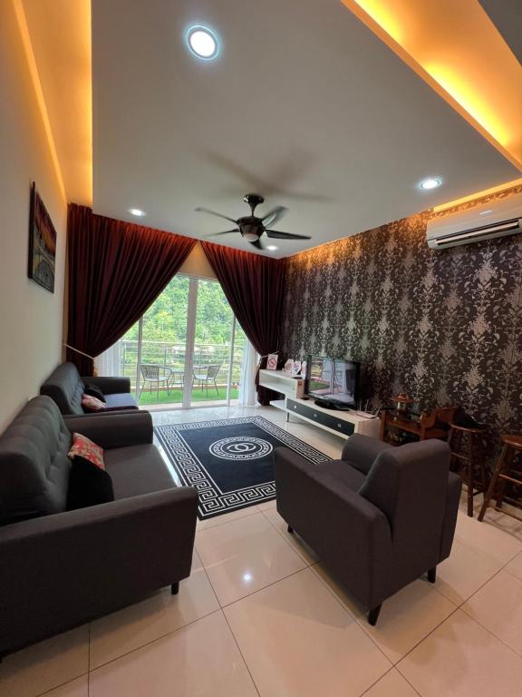 een woonkamer met 2 banken en een tv bij The Heaven Lakeside Residence Homestay by Quadvanos in Ipoh