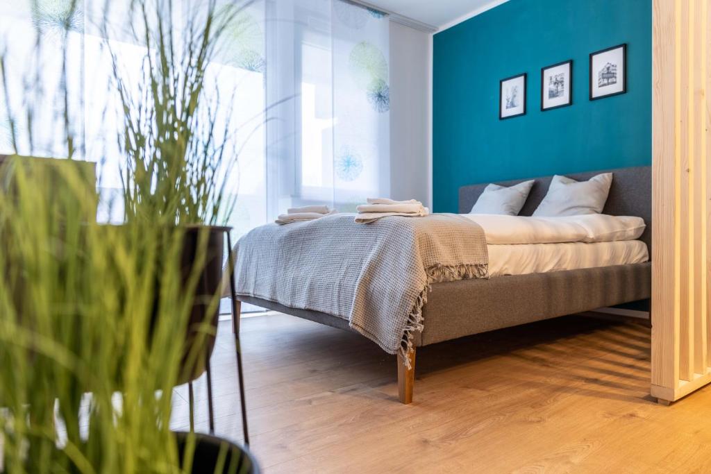 a bedroom with a bed with a blue wall at Munich Home in Munich