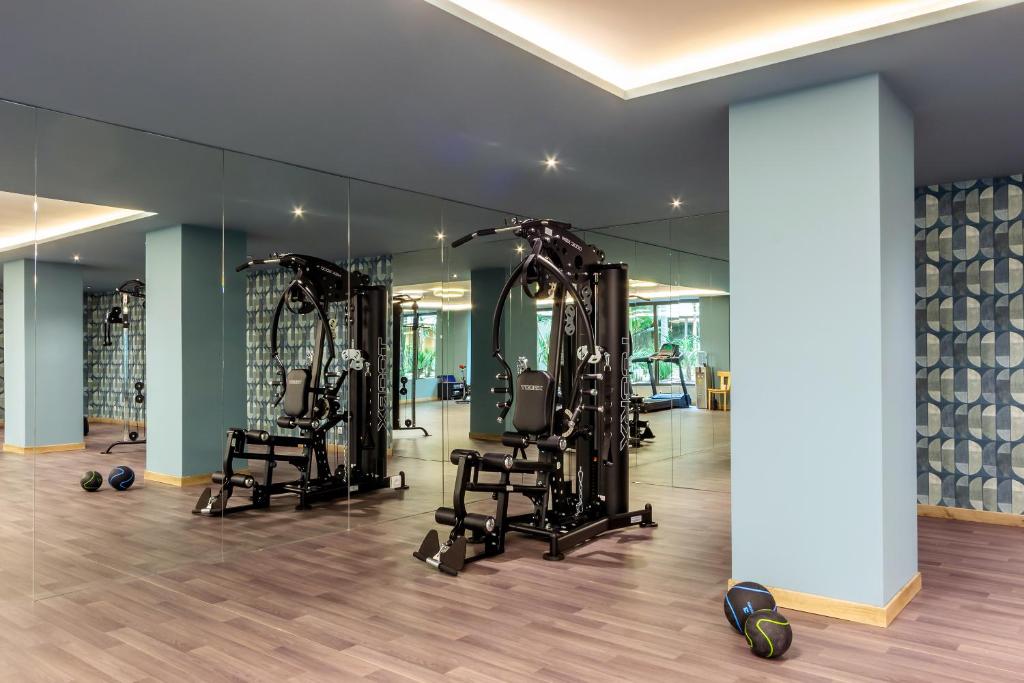 a gym with two treadmills and two mirrors at Ammoa Luxury Hotel & Spa Resort in Nikiti