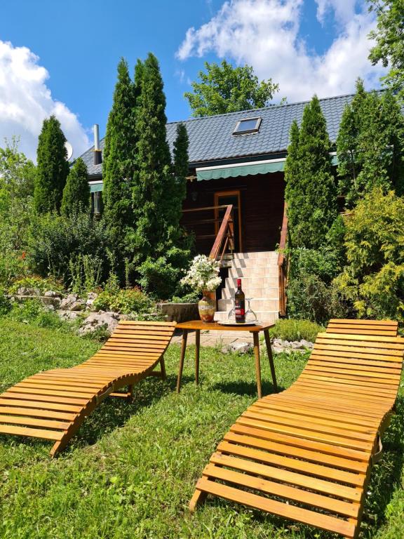 3 sillas de madera y una mesa en el césped en House Poljana, en Lagos de Plitvice