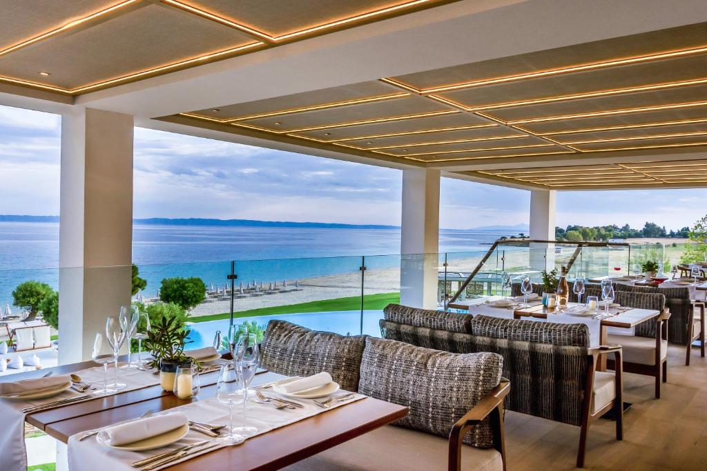a restaurant with a view of the ocean at Ammoa Luxury Hotel & Spa Resort in Nikiti