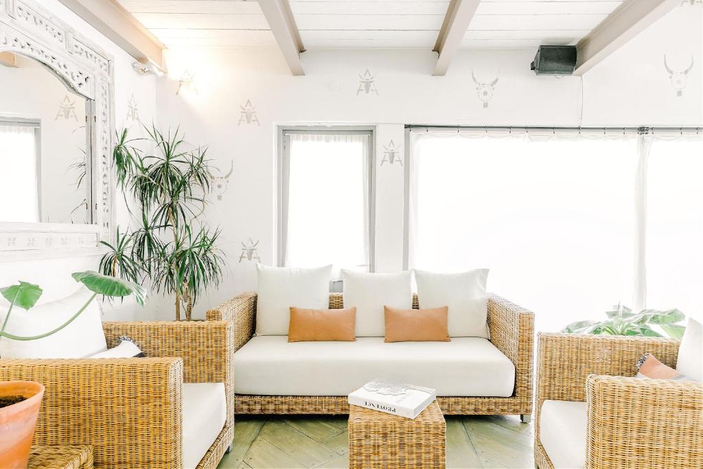 a living room with rattan chairs and a couch at Hôtel Restaurant Les Arnelles in Saintes-Maries-de-la-Mer