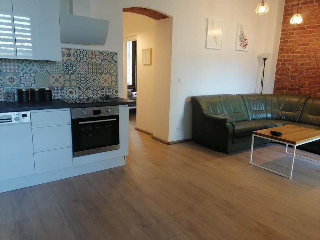 kuchnia i salon z kanapą i stołem w obiekcie Centrum Przy Promenadzie w mieście Mrągowo