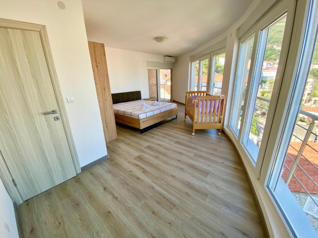 Zimmer mit einem Schlafzimmer mit einem Bett und Fenstern in der Unterkunft UpART House in Petrovac na Moru