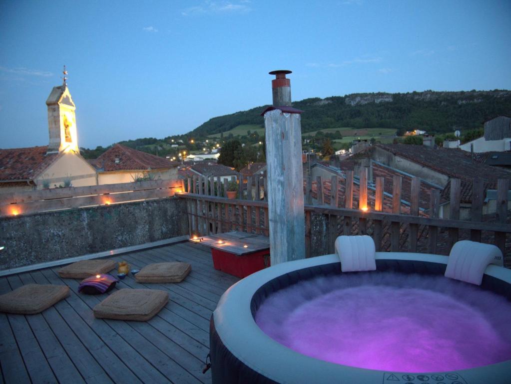 bañera de hidromasaje en la terraza de un balcón en Chaleureuse maison avec Jacuzzi en Le Mas-dʼAzil