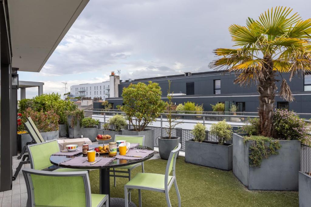 d'une terrasse avec une table et des chaises sur un balcon. dans l'établissement ILLANKA - Appartement 3 chambres avec parking et terrasse proche gare, à Rennes