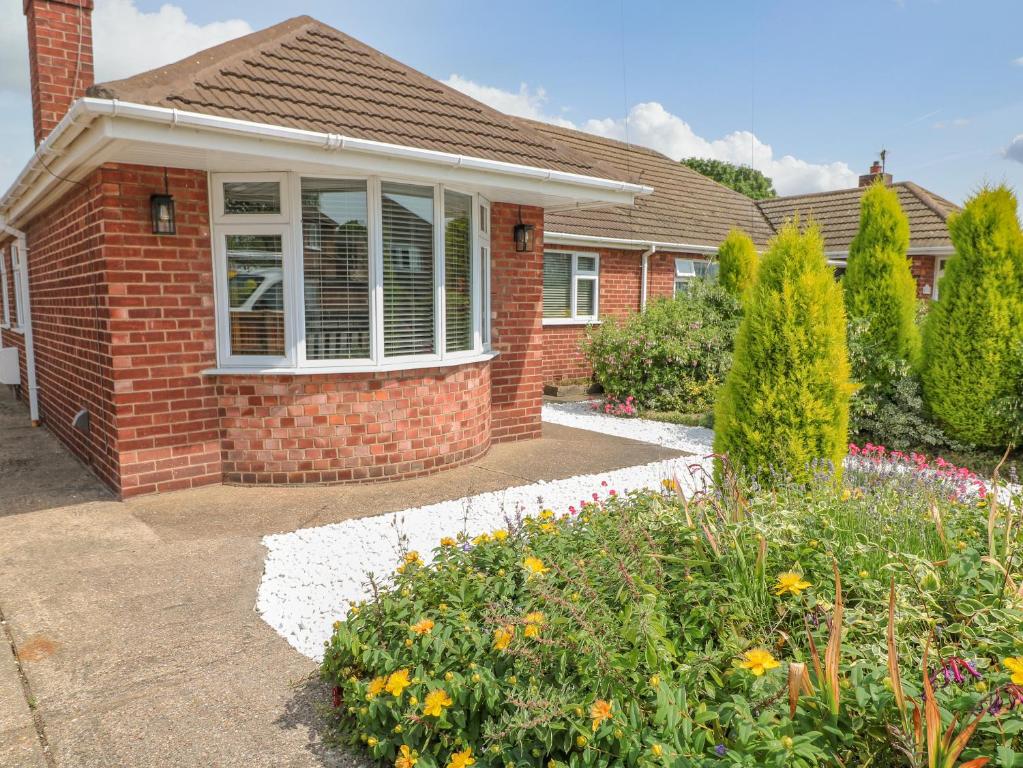 a brick house with a garden in front of it at Broadway Cottage in Lincoln