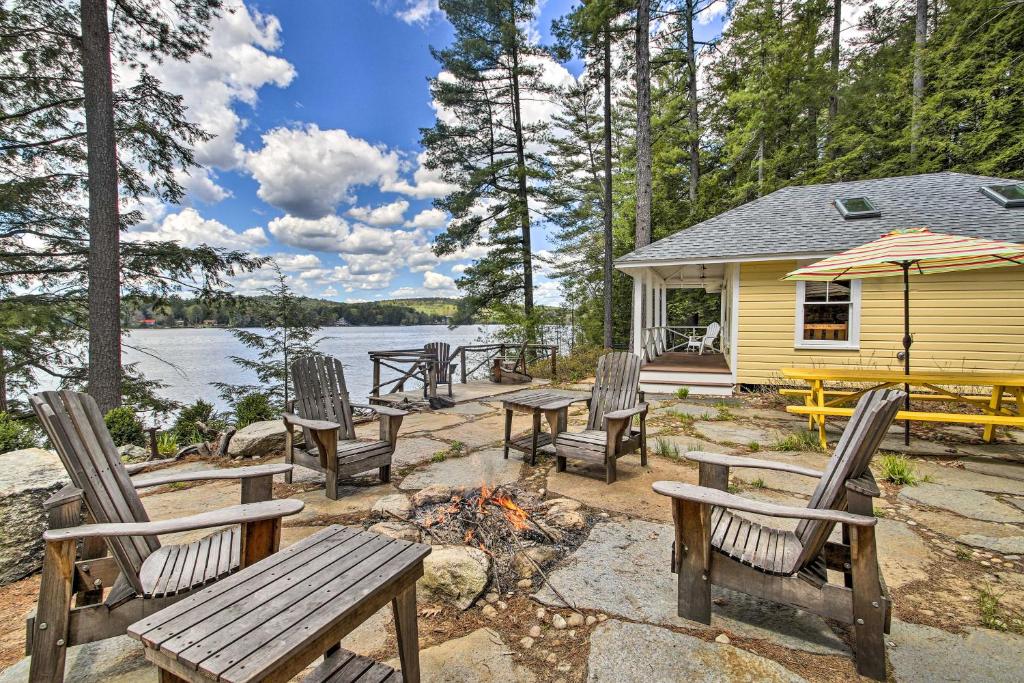 a group of chairs around a campfire in front of a house at Lakefront Cottage Boat Dock, Patio and Kayaks! in Oxford