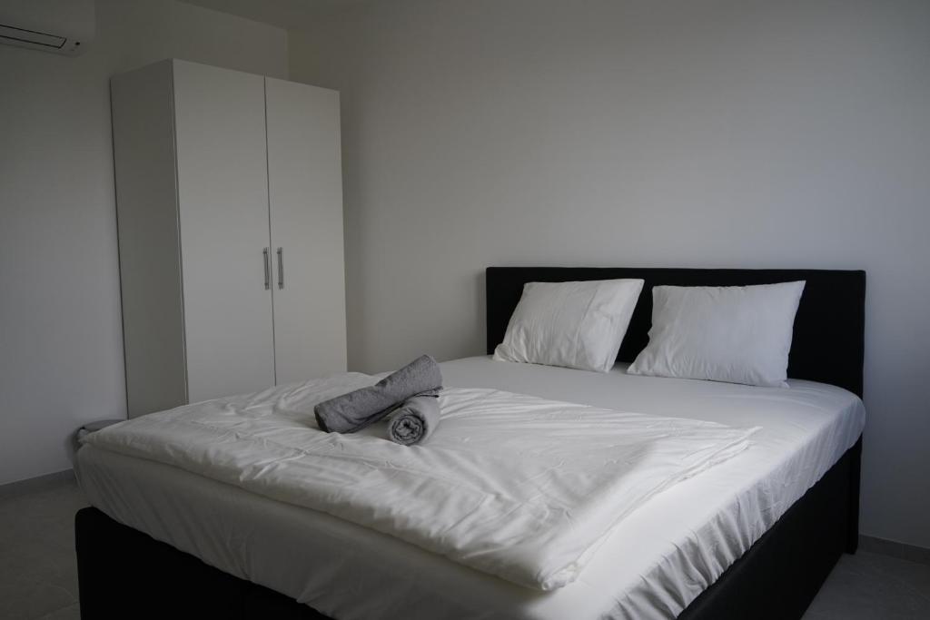 1 cama grande con sábanas blancas y almohadas blancas en DM Apartment, en Viena