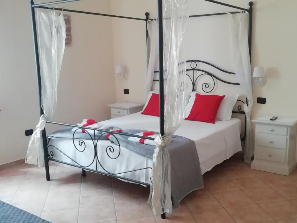 1 dormitorio con cama con dosel y almohadas rojas en City life Pompeii -Suite King Deluxe en Pompei
