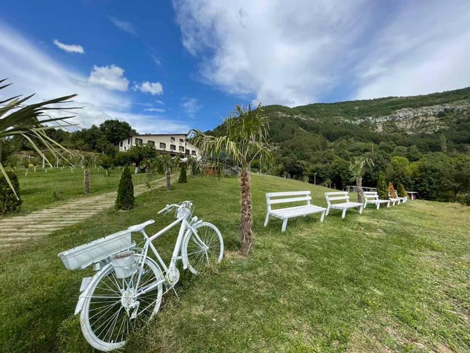 a white bike parked next to a row of benches at Family hotel Borovitsa in Pŭdartsi
