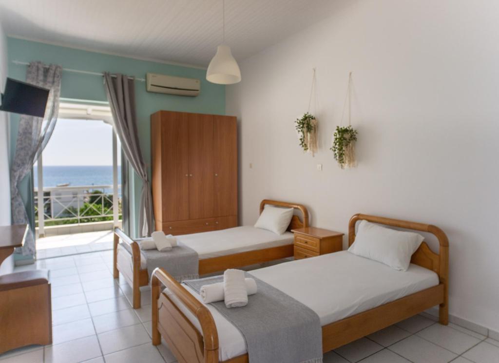 een hotelkamer met 2 bedden en een balkon bij Fuga Rooms in Kanali