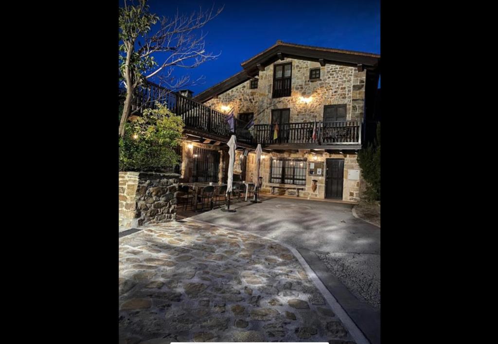 a large stone house with a stone driveway at Posada y Apartamentos Trebuesto de Guriezo in Trebuesto