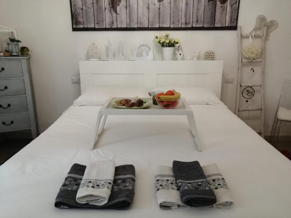 białe łóżko z tacą z talerzem jedzenia w obiekcie La luminaria w mieście Bari