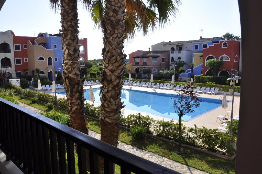 balcone con palme e vista sulla piscina. di Basilicata Host to Host - BORGO SAN BASILIO a Marina di Pisticci