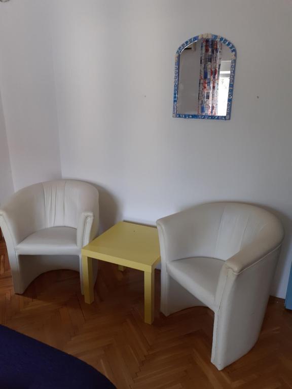 a room with two chairs and a table and a mirror at Guest House Vila Bak in Budva