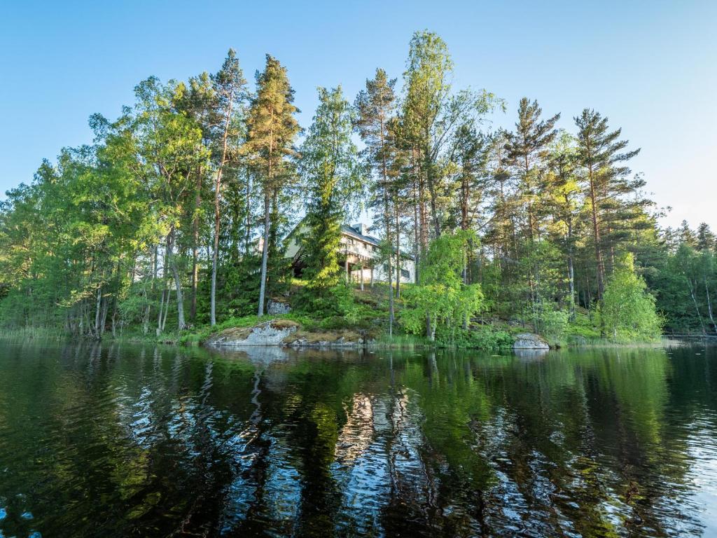 a house on a small island in the middle of a lake at Polku Hotelli in Vihti