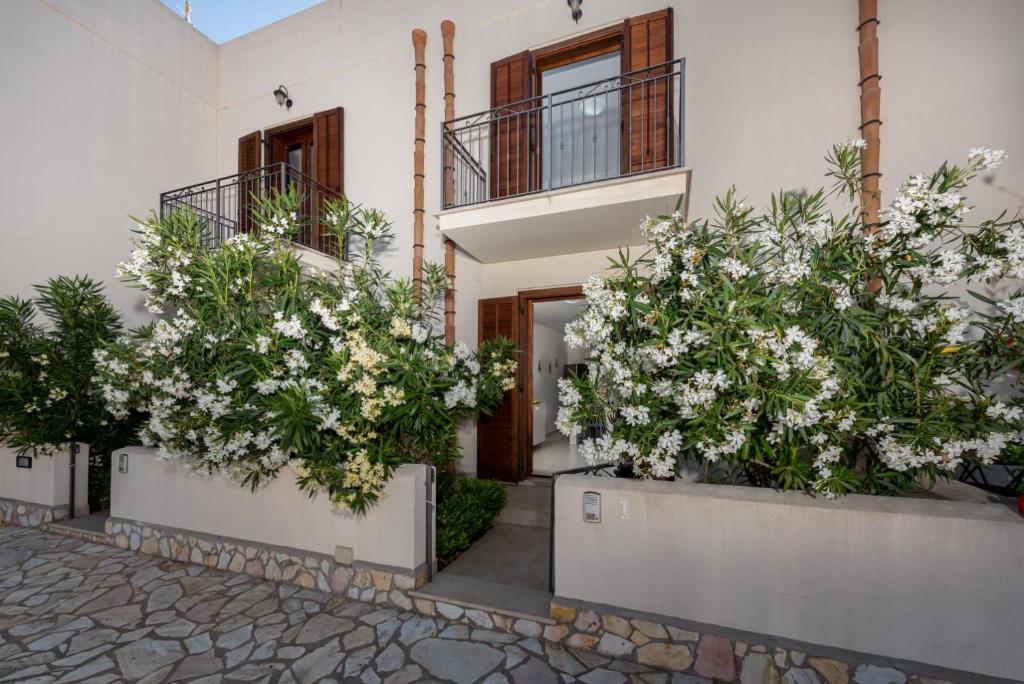 a house with white flowers in front of it at Le case di San Vito in San Vito lo Capo