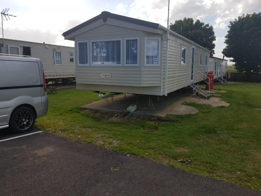 a tiny house is parked next to a van at St Osyth New Holiday Home in Jaywick Sands