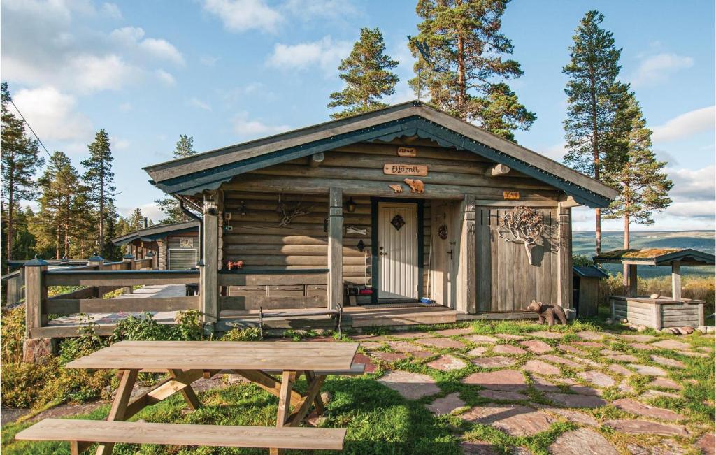 Awesome Home In Ljrdalen With Kitchen في Ljørdal: كابينة خشبية أمامها طاولة نزهة