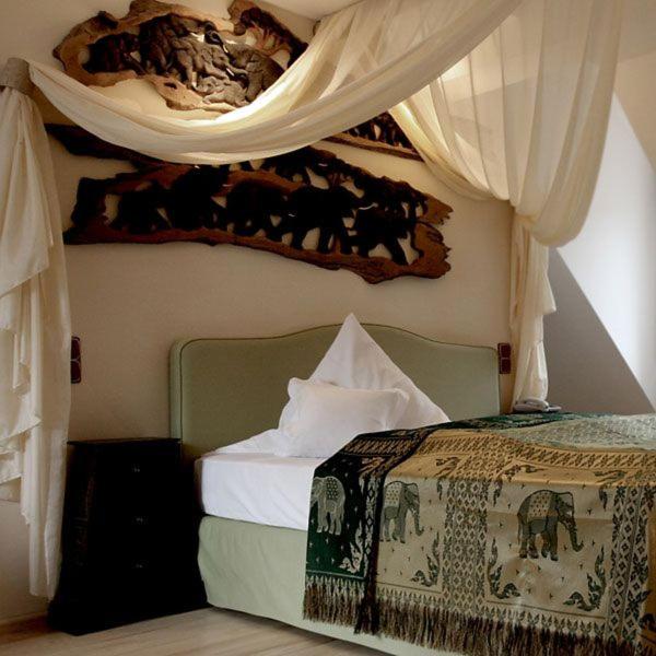 a bedroom with a bed with a painting on the wall at HIP Hotel in Heidelberg