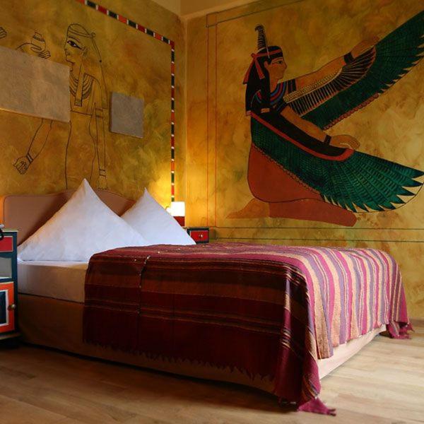 a bedroom with a bed with a painting on the wall at HIP Hotel in Heidelberg