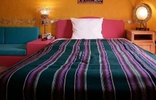 a bedroom with a large bed with a colorful blanket at HIP Hotel in Heidelberg