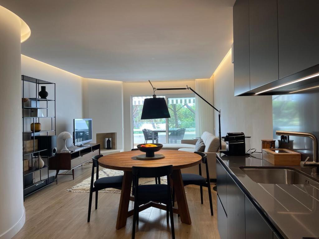 cocina y sala de estar con mesa de madera en una habitación en Victory Village 10C, en Quinta do Lago