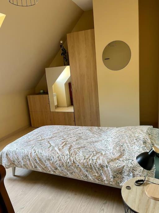 a bedroom with a bed and a table with a lamp at L&#39;écureuil de la Baie - maison en Baie de Somme in Mons-Boubert