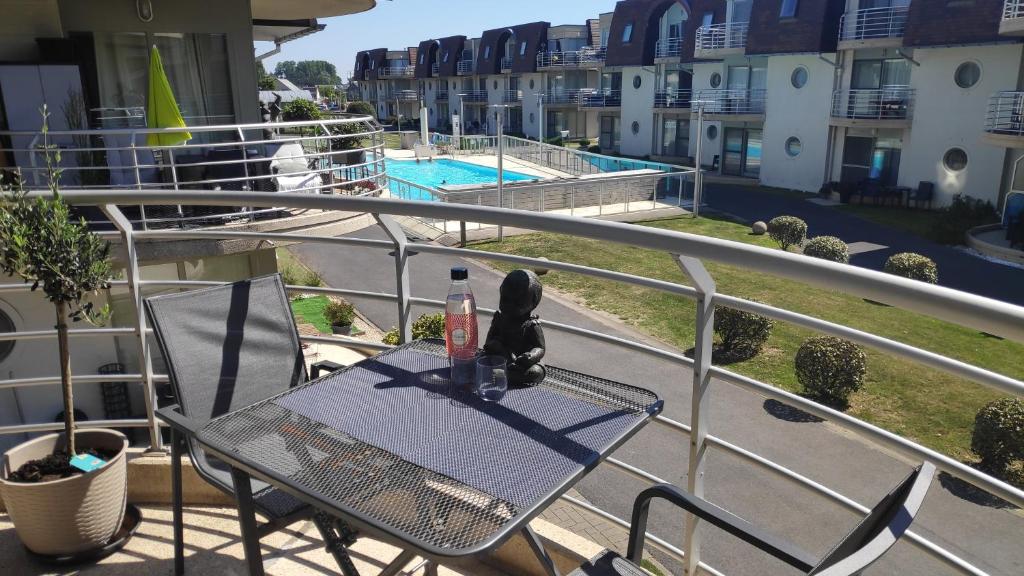a table and chairs on a balcony with a view of a pool at Blutsyde Promenade Encanto in Bredene