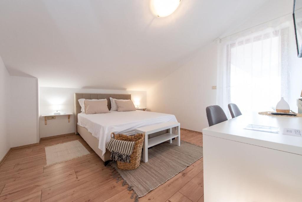 Habitación blanca con cama y escritorio en Guest house DaLi, en Rovinj