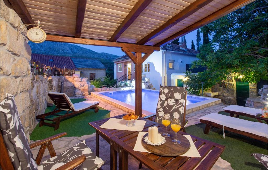 un patio con mesa, sillas y piscina en Nice Home In Srinjine With Wifi, en Srinjine