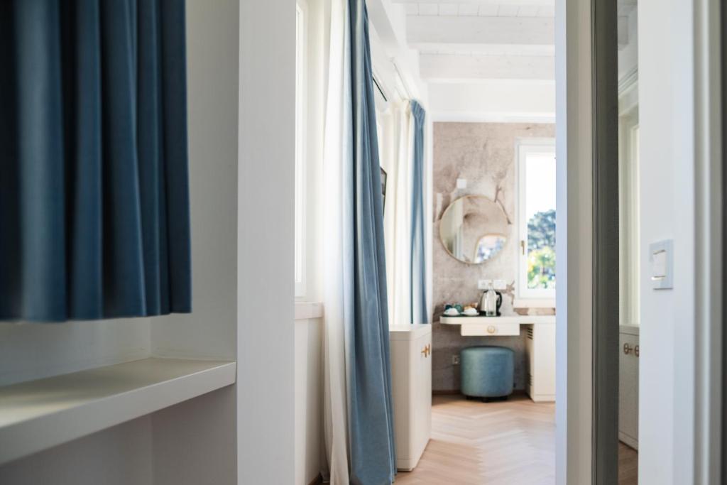 een hal met blauwe gordijnen en een badkamer met een wastafel bij LUXURY SUITES ROCOPOM - Lake Front in Lecco