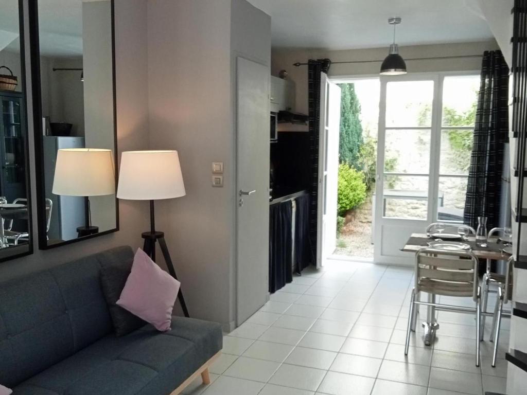 uma sala de estar com um sofá azul e uma mesa em Appartement Saint-Martin-de-Ré, 3 pièces, 4 personnes - FR-1-544-20 em Saint-Martin-de-Ré