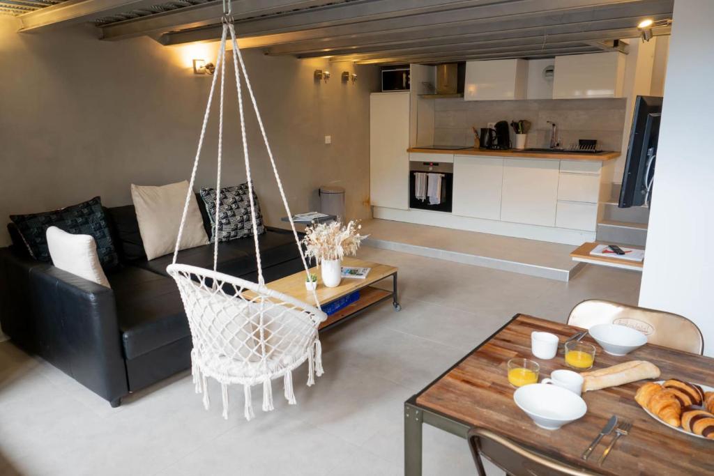 - un salon avec un fauteuil suspendu et un canapé dans l'établissement Loft Gramont  Cozy Studio - au calme - centre ville - tout à pied, à Biarritz