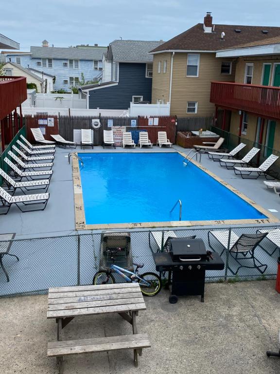 a large swimming pool with a picnic table and a bench at Offshore Motel in Seaside Heights