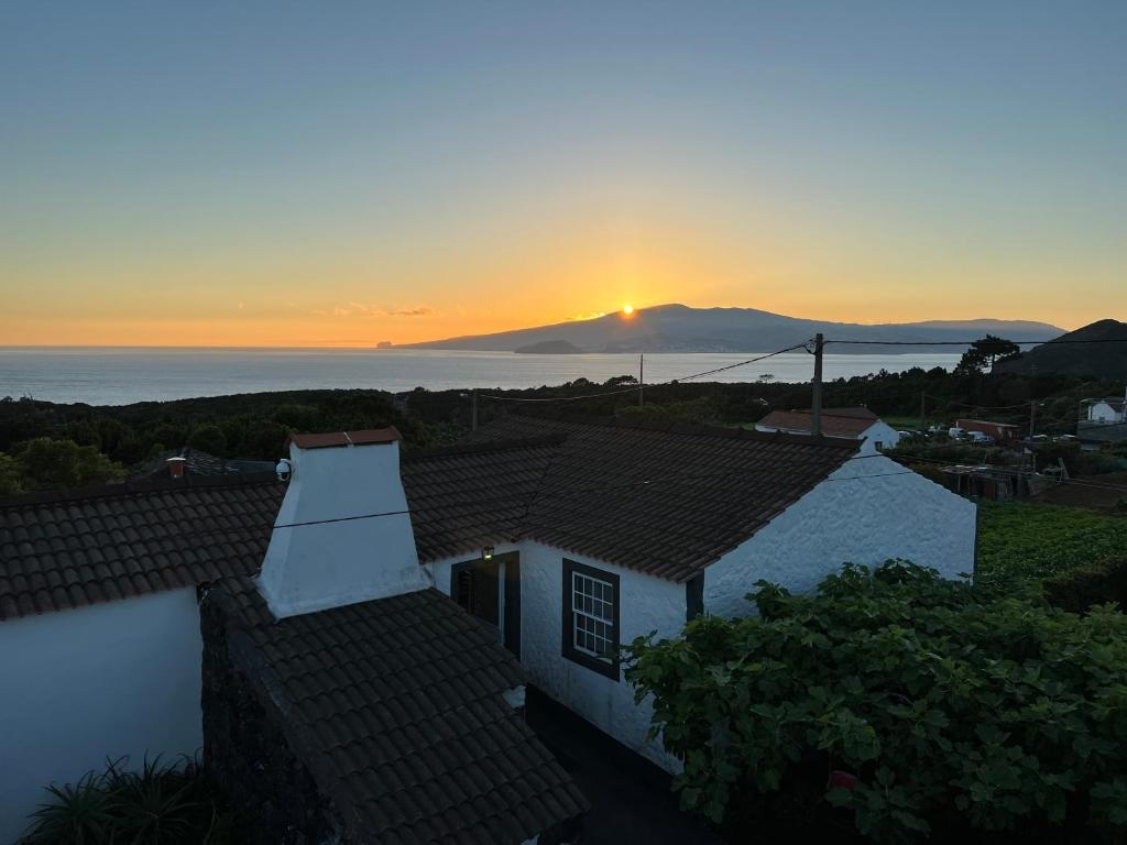 Blick auf den Sonnenuntergang vom Dach eines Hauses in der Unterkunft Rosa do Canto in Monte