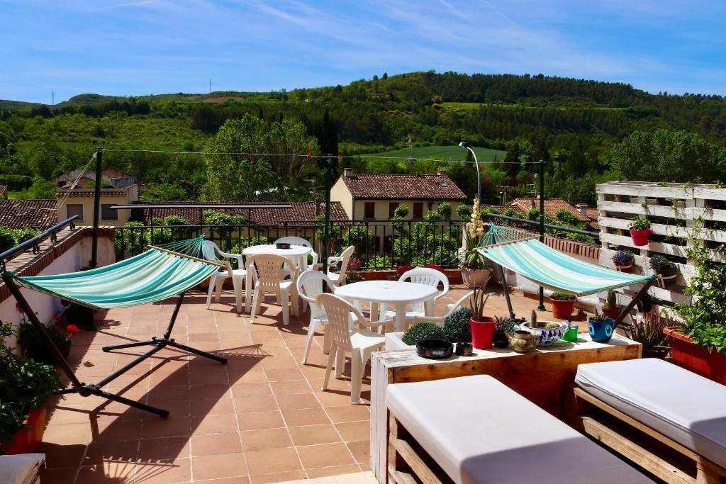 a patio with tables and chairs on a balcony at Albergue Puente para peregrinos in Puente la Reina