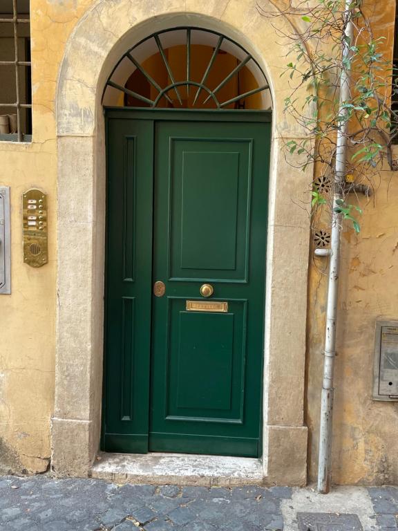 ローマにあるRegolaのアーチのある建物の緑の扉