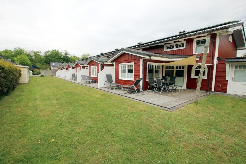 eine Reihe von roten und weißen Häusern mit einem Hof in der Unterkunft Susanne-Fischer Weg 37, Haus Einsiedlerkrebs in Wyk auf Föhr