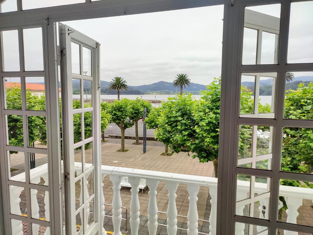 uma vista a partir de uma janela de uma varanda com palmeiras em Alameda House em Santa Marta de Ortigueira