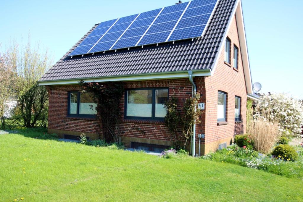 a house with solar panels on the roof at Linge 4_ Whg_ 1_ Hygge in Wrixum