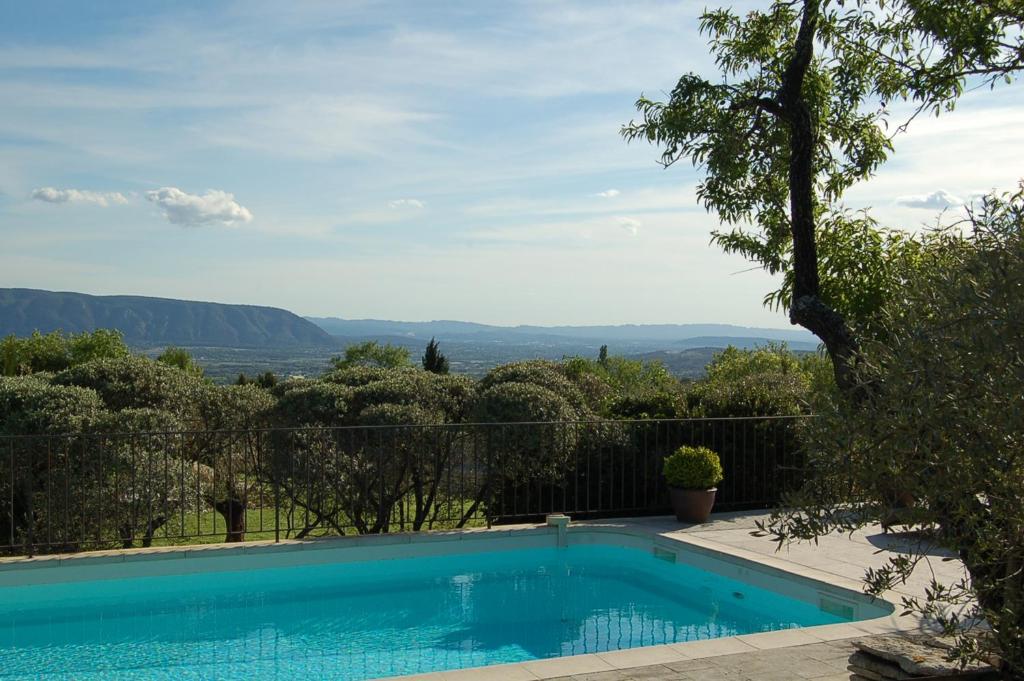 a swimming pool with a view of the mountains at Mas de la Beaume in Gordes