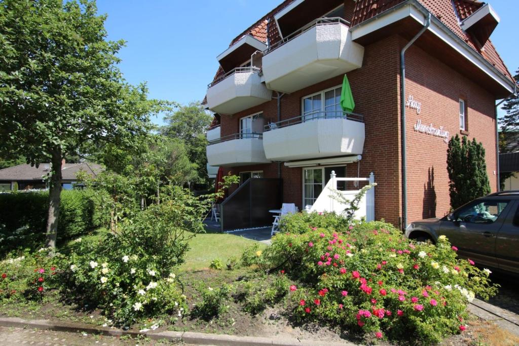 een gebouw met een balkon en bloemen ervoor bij Gmelinstra_e 12_ Whg_ 18_ Haus Mee in Wyk auf Föhr