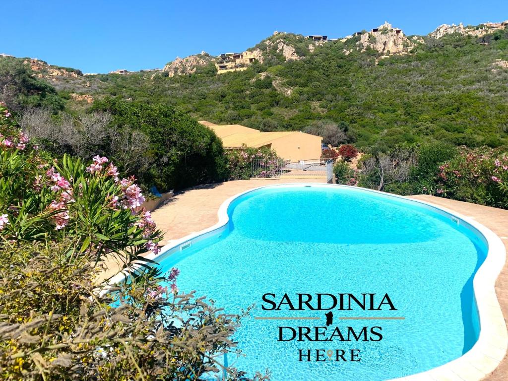 una piscina con un cartel que lee sueños sardinianos aquí en Villetta Sapphire con piscina, en Costa Paradiso