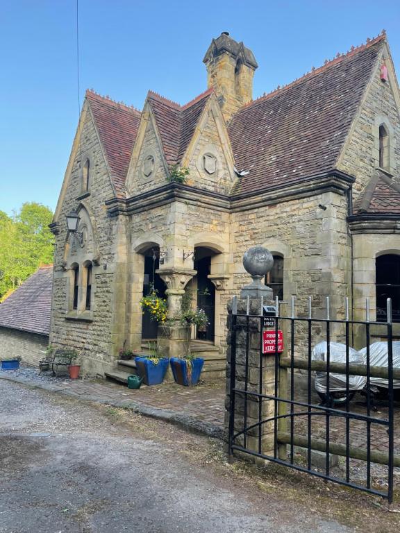 an old stone building with a gate in front of it at South Lodge House in Dormans Land