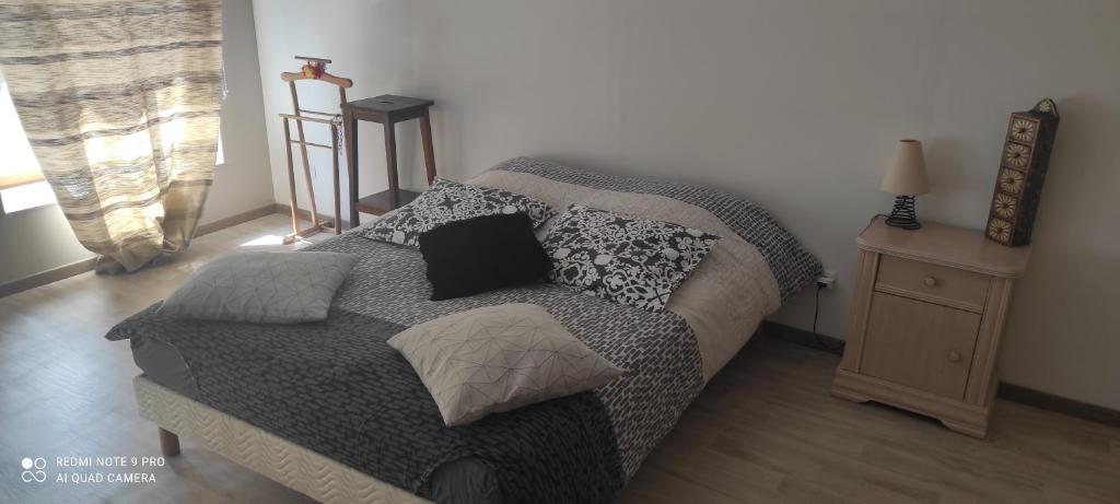 1 dormitorio con 1 cama y 1 mesa con lámpara en Les plaisirs de la ruralité, en Vendresse