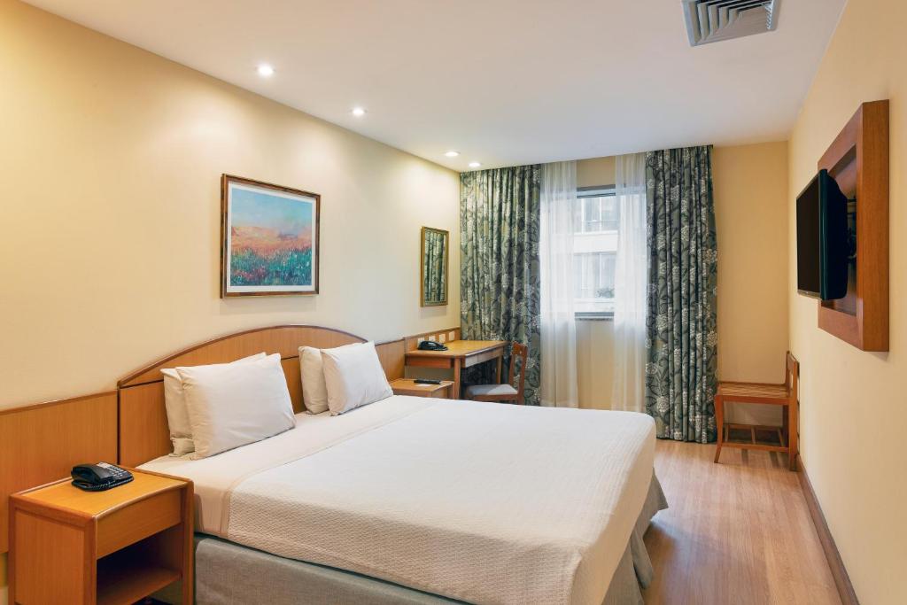 a hotel room with a bed and a window at Windsor Martinique Copacabana in Rio de Janeiro
