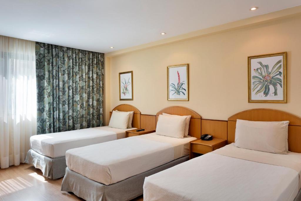 a hotel room with two beds and a window at Windsor Martinique Copacabana in Rio de Janeiro