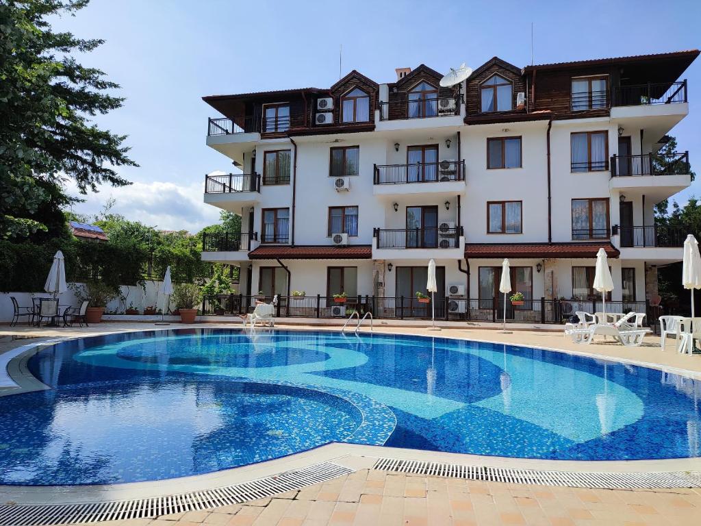 a hotel with a large swimming pool in front of a building at Sirena condo 50 m from the central beach in Byala
